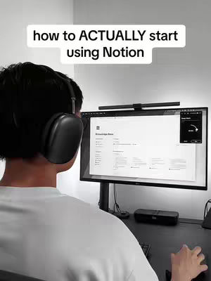The video cover shows a person from behind, wearing headphones, sitting in front of a computer on a dark desk. Above the person's head is a white text overlay that reads, "how to ACTUALLY start using Notion". The person is in front of a desktop monitor displaying a Notion interface and its timer.