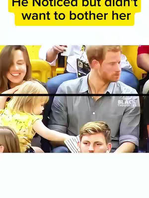 The image shows a well-dressed man seated in a crowd. In the foreground, a small child is interacting with the man. In the background, another woman is seen. The composition suggests a candid moment.