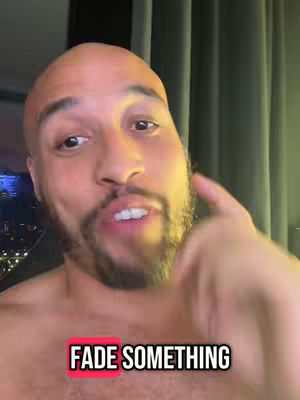 A man with a bald head and a short beard is pointing with his right index finger toward the viewer. The text overlay "FADE SOMETHING" in a white font within a red-bordered box is present at the bottom. The background suggests an indoor setting with dim green lighting.