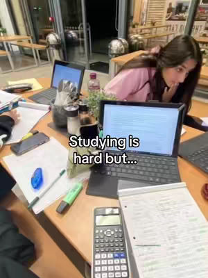 A cover image shows a workspace with a laptop open on a wooden table, a woman is sitting near the laptop, there are several items on the table visible such as highlighter, calculator, pens. A text overlay says "Studying is hard but..."