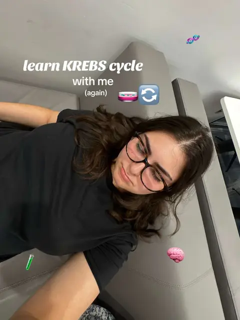 A person with dark hair and glasses lies on a gray couch, with text overlayed above. The text says, "learn KREBS cycle with me (again)". Decorative elements such as a Petri dish, a reload icon, and a brain are also present. The background is neutral.