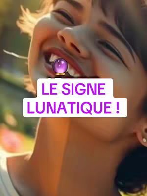A close-up shot shows a woman with a wide smile, her head tilted back. Overlayed on her lips is a crystal ball set on a golden base, and a white rectangular text overlay with the words "LE SIGNE LUNATIQUE !" in purple. The background is softly blurred with green hues.