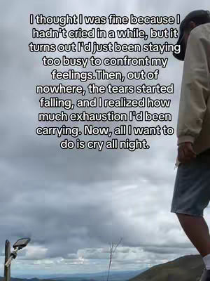 A man stands on a hill overlooking a cloudy landscape. Text overlayed on the image tells a story about suppressing emotions and realizing exhaustion.