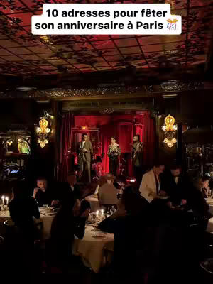 The cover photo captures a restaurant scene with a band performing on a stage in the background. In the foreground, several tables are set for dining, with guests seated, and candles lit. The space has a classic decor, with dark tones, fancy chandeliers and red curtains.
