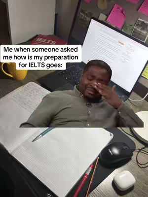 The cover image shows a person, likely the creator, in a setting that appears to be an office or study space. The person is a Black man shown from the chest up, with a slightly blurred background including a laptop screen. He is holding his hand up to his eye and appears to be wiping away tears, which suggests an emotional response. The image is a meme referencing IELTS preparation with text overlay.