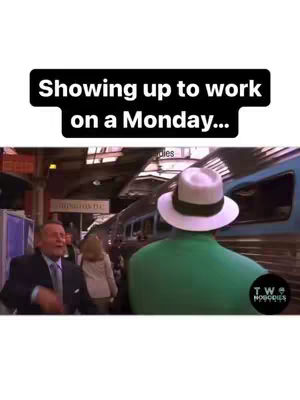 The cover image shows a scene at a train station, with the back of a man wearing a green jacket and a white hat as the focal point. The text overlay in a black rectangle reads 'Showing up to work on a Monday...'. It includes men, buildings, a train, all cast in daylight with a slightly muted color palette.