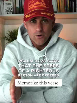 A man in a red hat and a gray hoodie is speaking to the camera. Overlay text promotes memorizing a Bible verse.