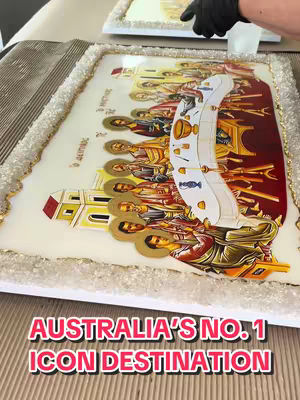 A religious icon of the Last Supper is shown, with the figures seated around a table. It is mounted on a white base with a textured, crystallized border with a gold trim. Overlaid on the image is text that reads "AUSTRALIA'S NO. 1 ICON DESTINATION" in a bold, red font.
