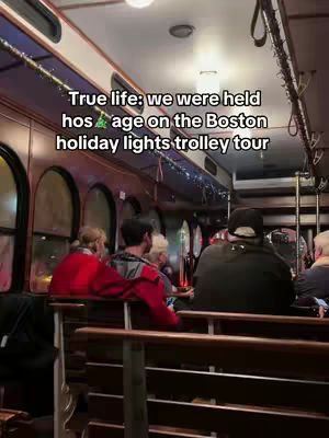 The cover image captures the interior of a trolley car. Several passengers are seated on wooden benches, with a few standing towards the back. The trolley's interior has rounded windows with a festive decoration. The trolley appears to be moving.