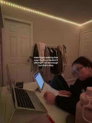 A dimly lit room featuring a person studying at a desk. A laptop and tablet are visible on the desk, with the person's hand and a bottle of water in the shot. The background consists of a closet and a door. Text is overlaid on the image.