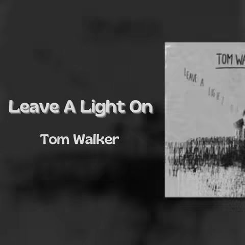 The cover image is a monochrome graphic with text overlayed. In the center left, the text "Leave A Light On" is prominently displayed in a thick, 3D-like white font. Below this, "Tom Walker" appears in a slightly smaller, simple white font. To the right, a framed black-and-white image is partially visible, likely a piece of artwork or a photo. The background's gradient black emphasizes the central text.
