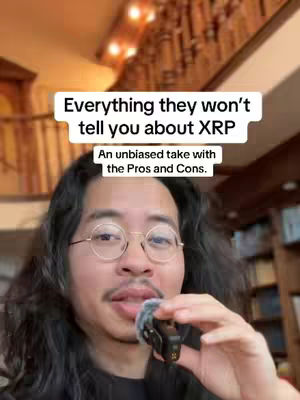 A man with long, dark hair and round glasses is holding a microphone and speaking. Above his head is a white text box with the video title. The background is a room with stairs and a lamp.