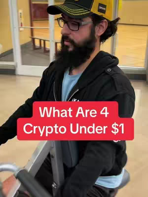 A man wearing eyeglasses, a baseball cap, and a beard is shown on a stationary bike. He is in a gym setting, with a text overlay in a red box that says, "What Are 4 Crypto Under $1".