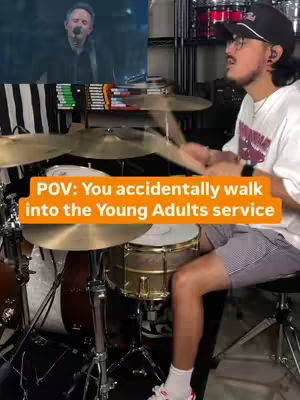 The cover image shows a man sitting behind a drum set, actively playing. The background has a video screen. Text overlayed reads "POV: You accidentally walk into the Young Adults service".