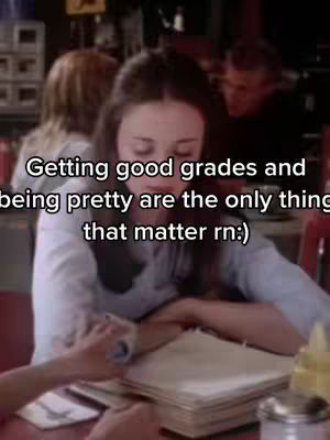 The cover image shows a scene from a television show, featuring two women at a table in a diner or restaurant setting. The main focus is on a young woman with long hair, who appears to be reading or studying, with an open book. The lighting suggests an indoor environment, and the color palette and the clothing give the sense of a scene captured at a moment in time.