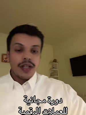 A man with a mustache and short black hair is speaking in a room. Below him in the frame is a text banner with Arabic script.