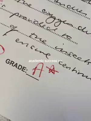 A close-up of a test paper with handwritten text and the grade "AA+" marked in red.