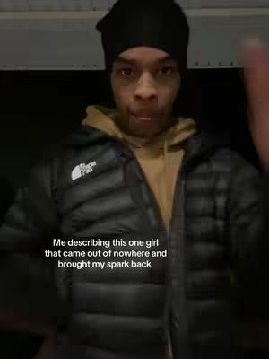 A person of ambiguous age and race, wearing a black beanie and a puffy black jacket, stands centered in the frame. The background is dark, possibly a room's dim interior. The person's gaze is directed toward the camera, and their posture is upright, but the overall impression is casual. Text overlays the lower portion of the frame, describing a personal anecdote.