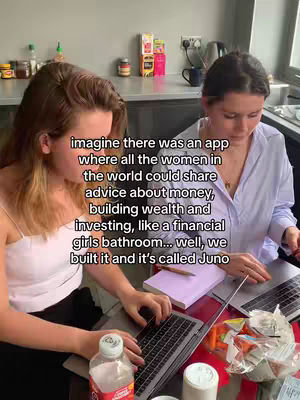 Two women are seated at a table, using laptops. The woman on the left is wearing a white top and has reddish-brown hair. The other woman is wearing a light blue button-up shirt. Text overlay is positioned in the center, describing an app concept.