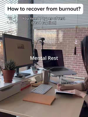 A well-lit workspace is shown with a desk occupied with a monitor, laptop, desk supplies, a small plant, and a person partially visible, writing in a notebook. Text overlays indicate the video discusses burnout and types of rest.
