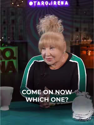 The cover image features a seated woman with blonde hair, wearing a black top with green stripes on the sleeves and a green tablecloth. In front of her sit a few objects. Text on the cover says, 'COME ON NOW WHICH ONE?'