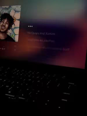 The image shows a laptop with a person's profile image on the left. The laptop screen is displaying a music app interface with song lyrics. The background is blurred, and the overall color scheme is dark with hints of gradients.