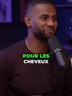 A medium shot shows a man with a beard and a fade haircut, holding a microphone and speaking. The text overlay reads 'POUR LES CHEVEUX.' The background appears to be a dimly lit room, and the man is wearing a dark shirt.