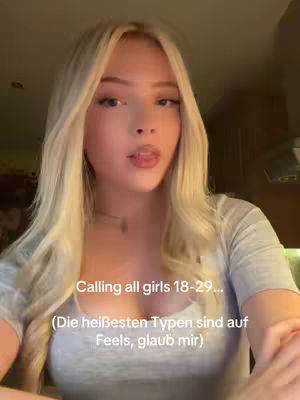 A selfie-style video cover image. The main subject is a young woman with long blonde hair, captured from the chest up. She is gazing directly at the camera with a subtle expression and a hint of a smile. The lighting appears to be soft, and the colors are natural, with a focus on the subject. Overlay text at the bottom of her chest provides more details about the context.