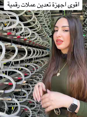 The cover image features a woman posing in front of a large server rack with rows of equipment. The text overlay reads "اقوى اجهزة تعدين عملات رقمية", set against a backdrop of white tubes and equipment. The woman is wearing a dark green top and appears to be giving a promotional look to the camera.