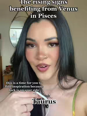 A woman with long, dark hair and makeup is centered in a selfie-style shot. Text overlays include the title "The rising signs benefiting from Venus in Pisces" and a smaller caption. The background shows a mirror, a glimpse of a room, and a partial view of a wooden surface.