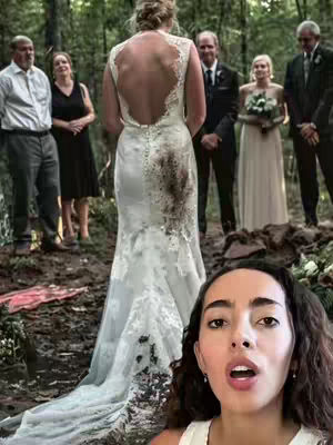 A woman with dark hair and an open mouth is in the bottom right corner, looking at the image. In the center, a bride is standing in a wedding dress with her back to the camera. The dress is white with a low back and has some dirt and stains on it. Several people are standing in the background, including a man in a suit, a woman in a black dress, and another woman in a white dress. The setting appears to be outdoors in a wooded area.