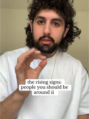 A close-up shot of a man with curly hair and a beard. He is making a gesture with his hand, with text overlay in a white rectangle.