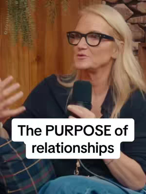 A woman with blonde hair and glasses is speaking into a microphone. Text overlay in a white box reads "The PURPOSE of relationships."