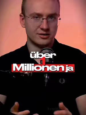 A man with fair skin and glasses is positioned in front of a reddish-orange background. He is wearing a black shirt and holding a microphone. Bold white text and a red banner are placed over the image.