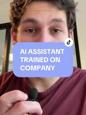 A man with brown hair and eyes is the central figure, viewed from a slightly upward angle. He's wearing a maroon shirt. In the foreground, a small microphone is positioned in front of his mouth. A light blue rectangular block with white text, "AI ASSISTANT TRAINED ON COMPANY", is placed over his face, and a TikTok logo sits on the top right of the box. The background consists of vague interior details.
