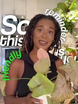 A woman with dark wavy hair is in a kitchen with plants in the background. She is holding a potted plant with pink and green leaves. Text overlays are present.