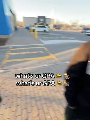 The image shows a blurry outdoor scene with paving stones, yellow parking lines, a building in the background, and a person partially visible on the right side, along with superimposed text.