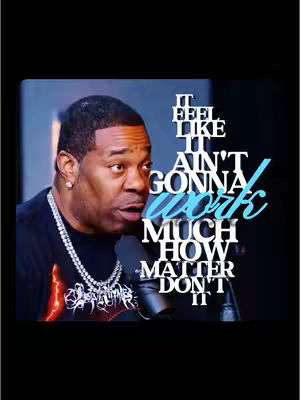 The cover image features a close-up of a man's face with overlaid text. The man, who appears to be a dark-skinned male, is positioned left of center. He's wearing a dark t-shirt and a silver chain necklace. Text in a stylized font saying “IT FEEL LIKE IT AIN’T GONNA WORK MUCH HOW MATTER DON’T IT” in white and light-blue is overlaid on the right side. The background is dark.