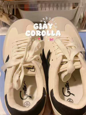 The cover image displays a close-up of a pair of cream-colored sneakers. The laces are tied, and the tongue of one shoe has the brand name 'Corolla' in a script font. Above the sneakers, the text 'unboxing' is arched and 'GIÀY COROLLA' is in the center, likely the product name. The overall setting seems to be indoors.