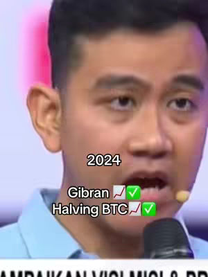 The cover image is a medium shot of a man speaking into a microphone. Added over the image are overlay texts like '2024,' 'Gibran ✅✓,' and 'Halving BTC ✅✓,' along with some graphical elements like checkmarks and trending up arrows.