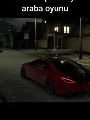 A video game screen capture featuring a red sports car driving on a dark street at night. The scene includes buildings, street lights, and a parked white car in the background.