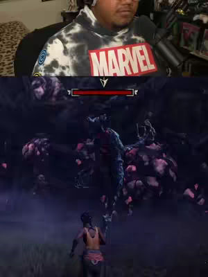 The cover image is split in two sections. The top half shows a creator wearing a tie-dye hoodie with a Marvel logo, headphones and glasses in front of a cluttered background. The bottom half is a screenshot from a video game featuring a dark scene with a creature rising from a dark background towards a running figure. The color palette is dark with hints of red and purple.