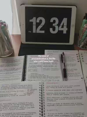 The cover image shows a workspace with an open notebook featuring handwritten notes and a digital clock displaying 12:34. A pen rests on the notebook, and a tablet displaying a digital clock sits in the background.