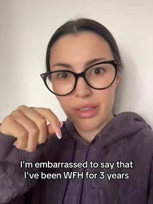 A woman with dark hair and glasses is looking directly at the camera. She is wearing a purple hoodie, and her hand is pointing down. Text at the bottom of the image reads: I'm embarrassed to say that I've been WFH for 3 years.