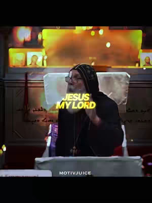 The image features a man in a black hooded garment with glasses, seemingly in a religious setting. Overlaid on the image is yellow text in a bubble font that reads "JESUS MY LORD."