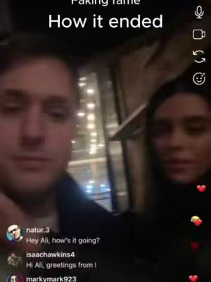 A selfie-style video cover shows a man and woman in a dimly lit indoor setting, possibly a bar or restaurant. The man is in the foreground, and the woman is slightly behind and to the right of him. The focus is on their faces, giving a sense of intimacy. There is text overlayed at the top of the screen.