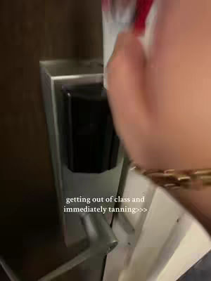 The image shows a hand reaching to open a door, with text overlayed. The hand is holding something, likely a phone or a key card, and is wearing a watch with gold chain.. The door frame and a black object are visible in the image.