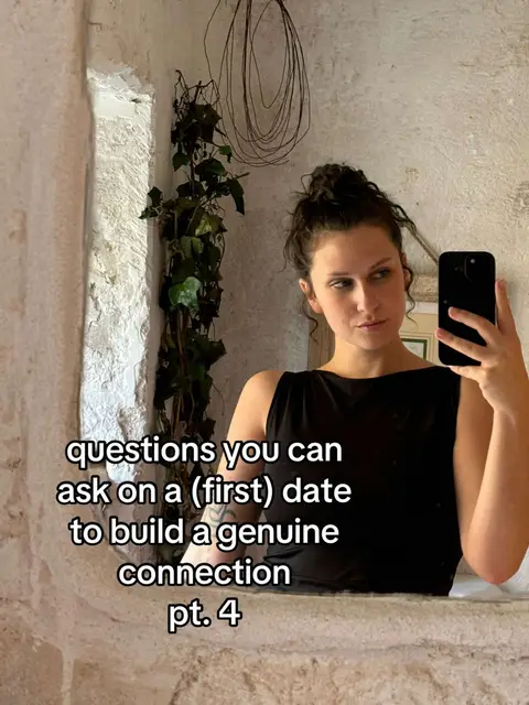 The cover image is a selfie in a mirror. The person is in front of a textured, light-colored wall. To the left of the frame is a decorative vine. The person is wearing a black top and holding a black phone, presumably taking the picture. A text overlay spans the bottom of the image, written in white font. The overall composition is simple, showing the creator in their real-world setting.