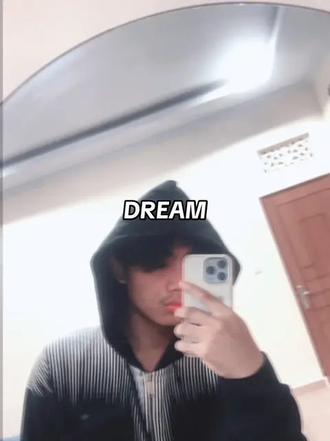 A person in a black hoodie is taking a selfie in a mirror. The word "DREAM" is overlaid on the image.