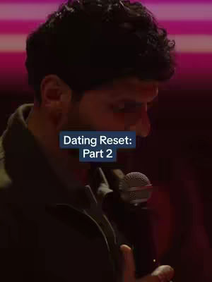 A man with dark hair stands in front of a blurred background, holding a microphone. A text overlay reading 'Dating Reset: Part 2' is centered on the image.